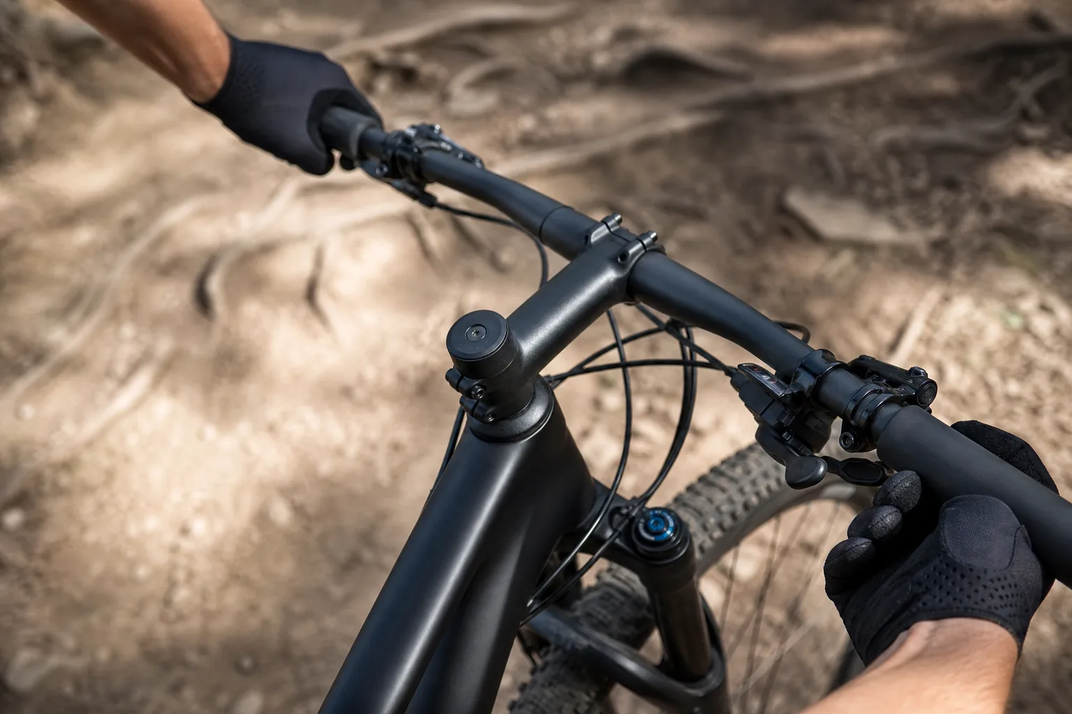 Mains gantées sur les grips et leviers de frein d’un VTT XC
