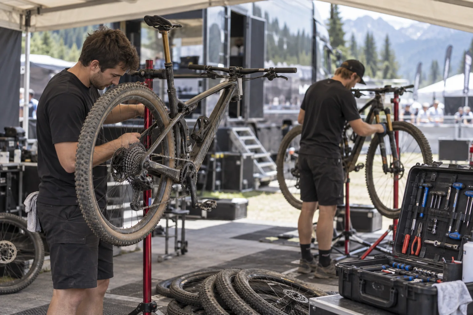 Mécaniciens préparant des vélos de cross-country dans un paddock d'équipe lors d'une Coupe du monde de VTT